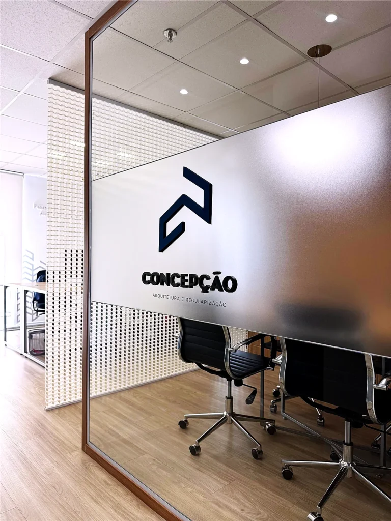 Sala de reunião envidraçada com a marca da Concepção no escritório em São Paulo